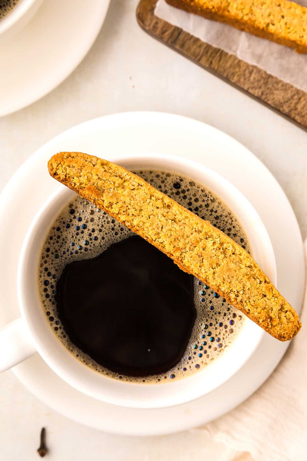 Top down image of a Keto Pumpkin Biscotto resting on top of a cup of coffee.