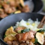 Chicken Zucchini Stir Fry in a black bowl with swirls on it.