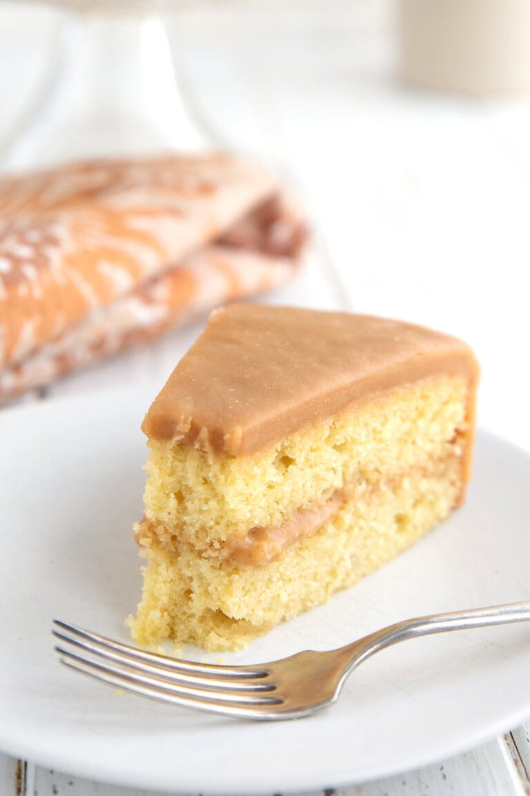 Close up shot of a slice of Keto Caramel Cake with a forkful taken out of it.