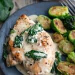 Titled image of keto chicken Florentine on a blue plate with Brussels sprouts.