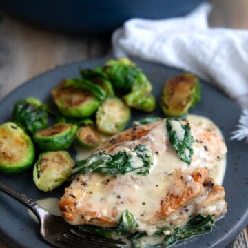 Creamy Keto Chicken Florentine on a gray plate with Brussels sprouts.