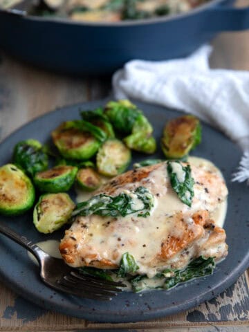 Creamy Keto Chicken Florentine on a gray plate with Brussels sprouts.