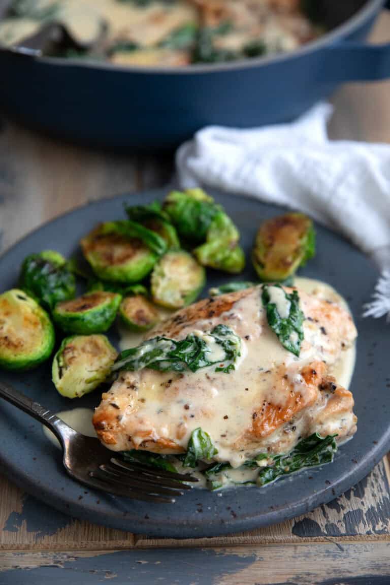 Creamy Keto Chicken Florentine on a gray plate with Brussels sprouts.