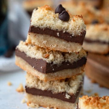 Close up shot of a stack of Keto Fudge Crumb Bars on a white table.