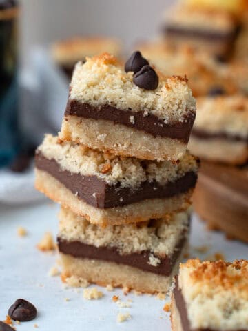 Close up shot of a stack of Keto Fudge Crumb Bars on a white table.