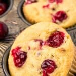 Close up titled image of a keto cranberry muffin sitting in a metal muffin tin.