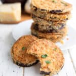 Pieces of Crispy Air Fryer Eggplant on a white table with a bite taken out of the front one.