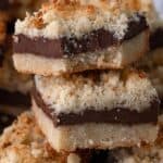 Titled image close up of Keto Fudge Crumb Bars with a bite taken out of the top one.