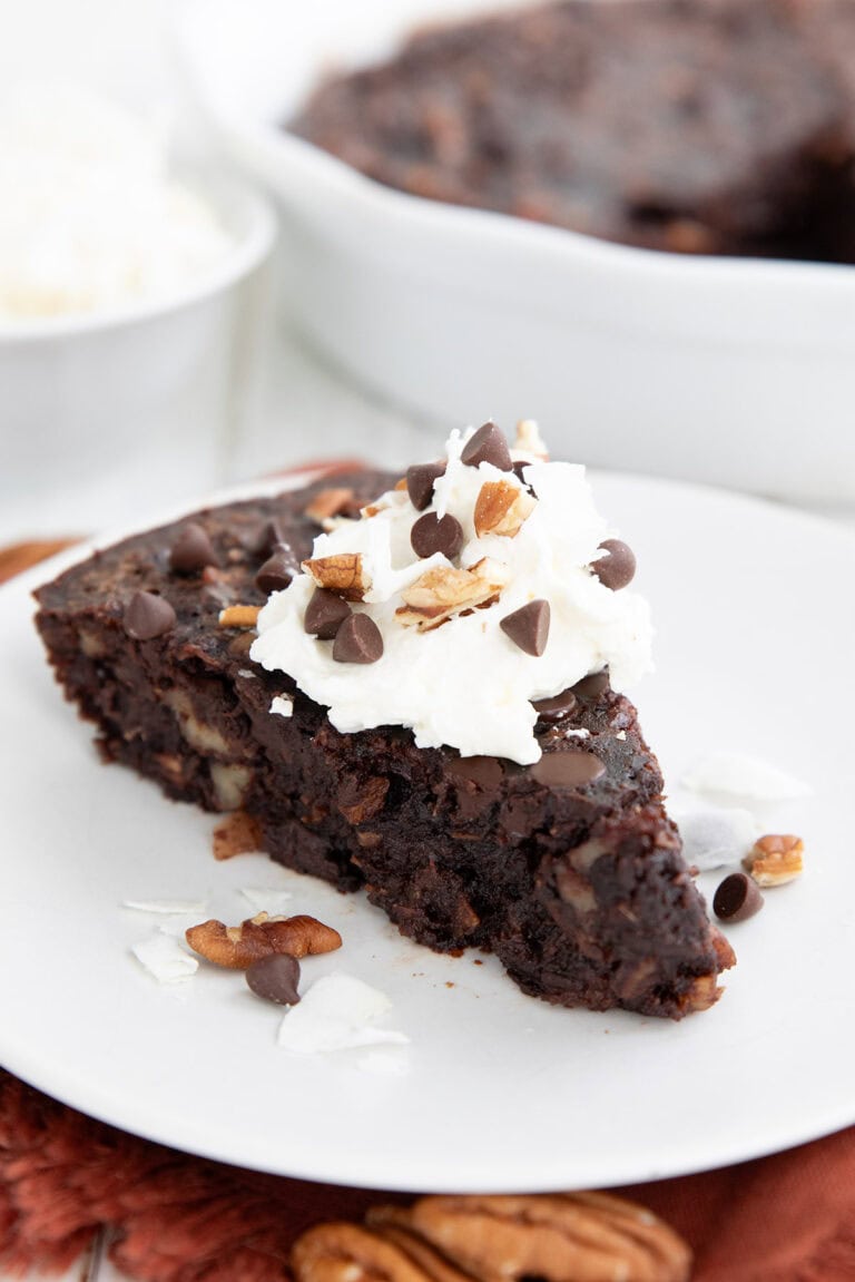 A slice of Keto German Chocolate Pie on a white plate over a dark orange napkin.