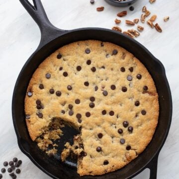 Top down image of a Keto Chocolate Chip Skillet Cookie with a scoopful taken out of it.