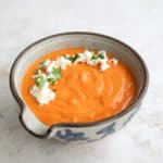 A patterned gray bowl filled with Roasted Red Pepper Feta Dip.