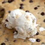 Close up shot with title across the top of a keto chocolate chip skillet cookie with ice cream on top.