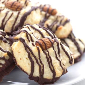 Close up shot of Keto Coconut Macaroons on a white plate on a white wooden table top.