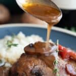 Titled image of a spoon pouring sauce over Keto Coq au Vin.