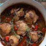 Top down image of a Dutch oven filled with Keto Coq au Vin on a dark wooden table.