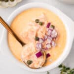 Top down image of a bowl of Smoked Salmon Chowder with a copper spoon in it.