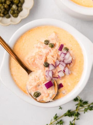 Top down image of a bowl of Smoked Salmon Chowder with a copper spoon in it.