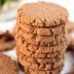 Titled image of a stack of Keto Gingersnap Cookies with a cinnamon stick and star anise in front.