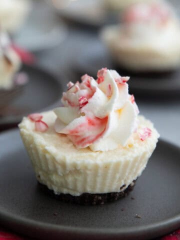 Close up shot of a Keto White Chocolate Peppermint Cheesecake on a gray plate.