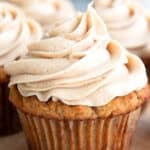 Titled image close up of Keto Spice Cake Cupcakes on a wooden cutting board.