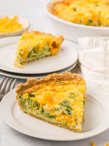 A slice of Keto Broccoli Cheese Quiche on a white plate with another slice in the background.