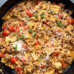 Titled image of chorizo and eggs in a large enameled skillet.