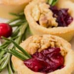 Titled image of Keto Cranberry Brie Bites on a white platter with sprigs of rosemary and fresh cranberries.