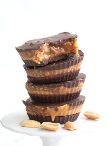 A stack of Keto Snickers Cups with a bite taken out of the top one.