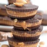 Close up shot of a stack of Keto Snickers Cups on a white wooden table.