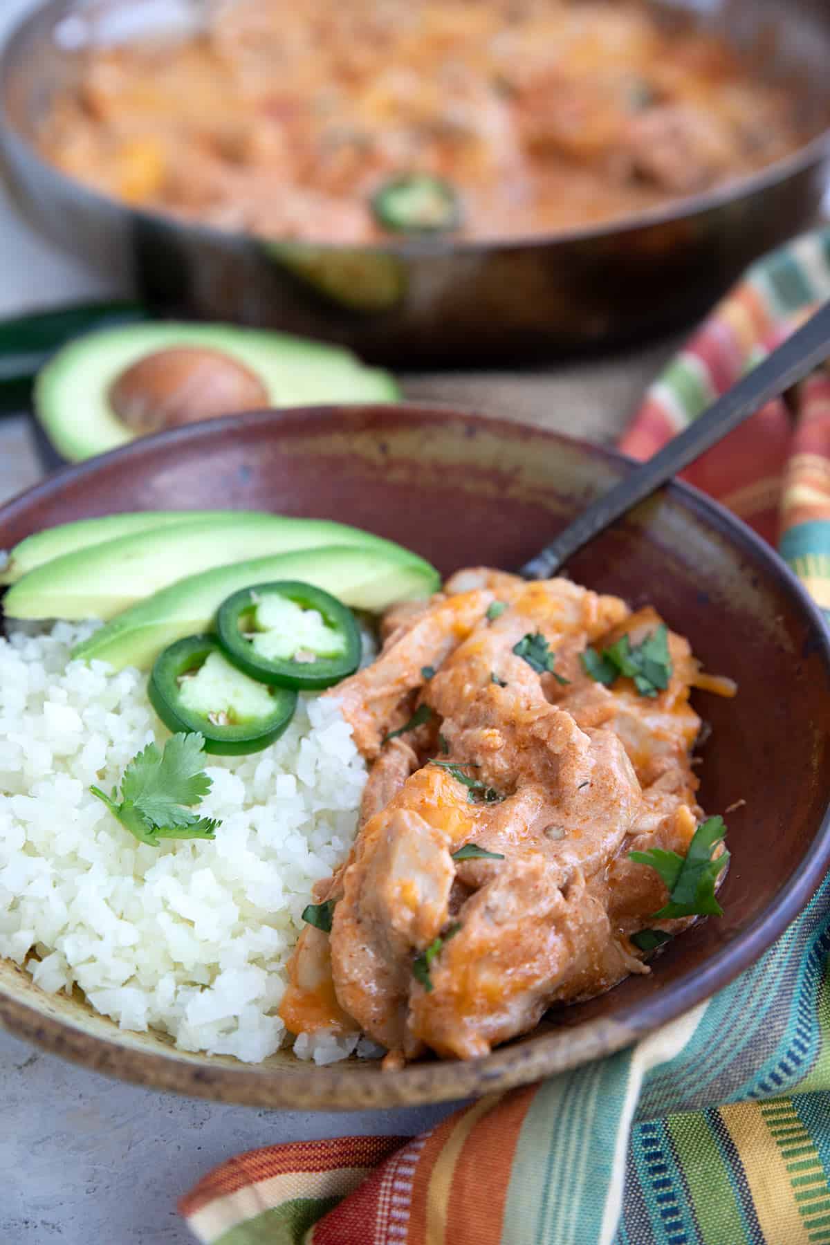 A bowl filled with Chicken Enchilada Skillet and cauliflower rice.