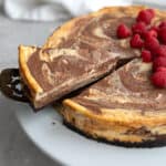 A slice of keto marble cheesecake being lifted away from the rest of the cake.