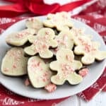 Pieces of peppermint bark in festive holiday shaped on a white plate over a red and white napkin.