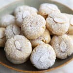 A rustic green plate piled with keto amaretti cookies.