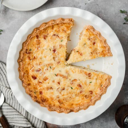 Top down image of Keto Quiche Lorraine in a white pie pan on a gray table.