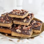 Keto Toffee Cookie Bars piled up on a gold colored plate.