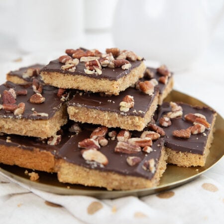 Keto Toffee Cookie Bars piled up on a gold colored plate.