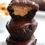 Titled image of a stack of Keto Buckeye Bites on a little white star-shaped plate, with the top one cut in half to show the inside.