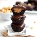 A stack of Keto Buckeye Bites on a little white star-shaped plate, with the top one cut in half to show the inside.