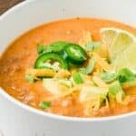 Titled image of Keto Taco Soup in a white bowl with cheese, avocado, and jalapeños on top.