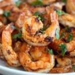 Close up shot of Chili Garlic Shrimp piled up in a white bowl.