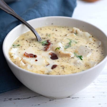 Close up shot of a white bowl filled with keto seafood chowder.
