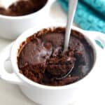 Keto Protein Mug Cake in a white ramekin with a small metal spoon digging into it.