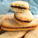 Titled image of a pile of Keto Milano Cookies with the top one broken in half.
