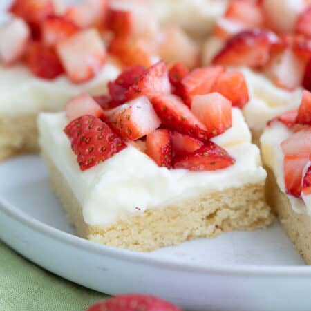 Close up shot of Keto Strawberry Shortcake Bars on a white plate over a green napkin.