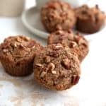 Close up shot of Keto Brown Butter Pecan Muffins piled up on a marble table top.