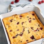Keto Cottage Cheese Breakfast Bake in a white ceramic pan with fresh berries scattered in the background.