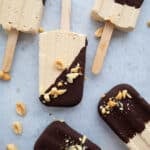 Top down image of Keto Peanut Butter Popsicles dipped in chocolate, laying on a piece of waxed paper.