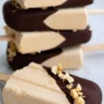 Titled image of a stack of Keto Peanut Butter Popsicles with one in front.