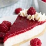 Titled image of a slice of Keto Raspberry Cream Pie on a white plate with fresh raspberries.