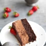 A slice of Keto Chocolate Mousse Cake on its side, on a white plate, with a forkful taken out of it.